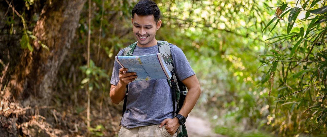 A man happy looking at the maps for his best trekking sites in nepal
